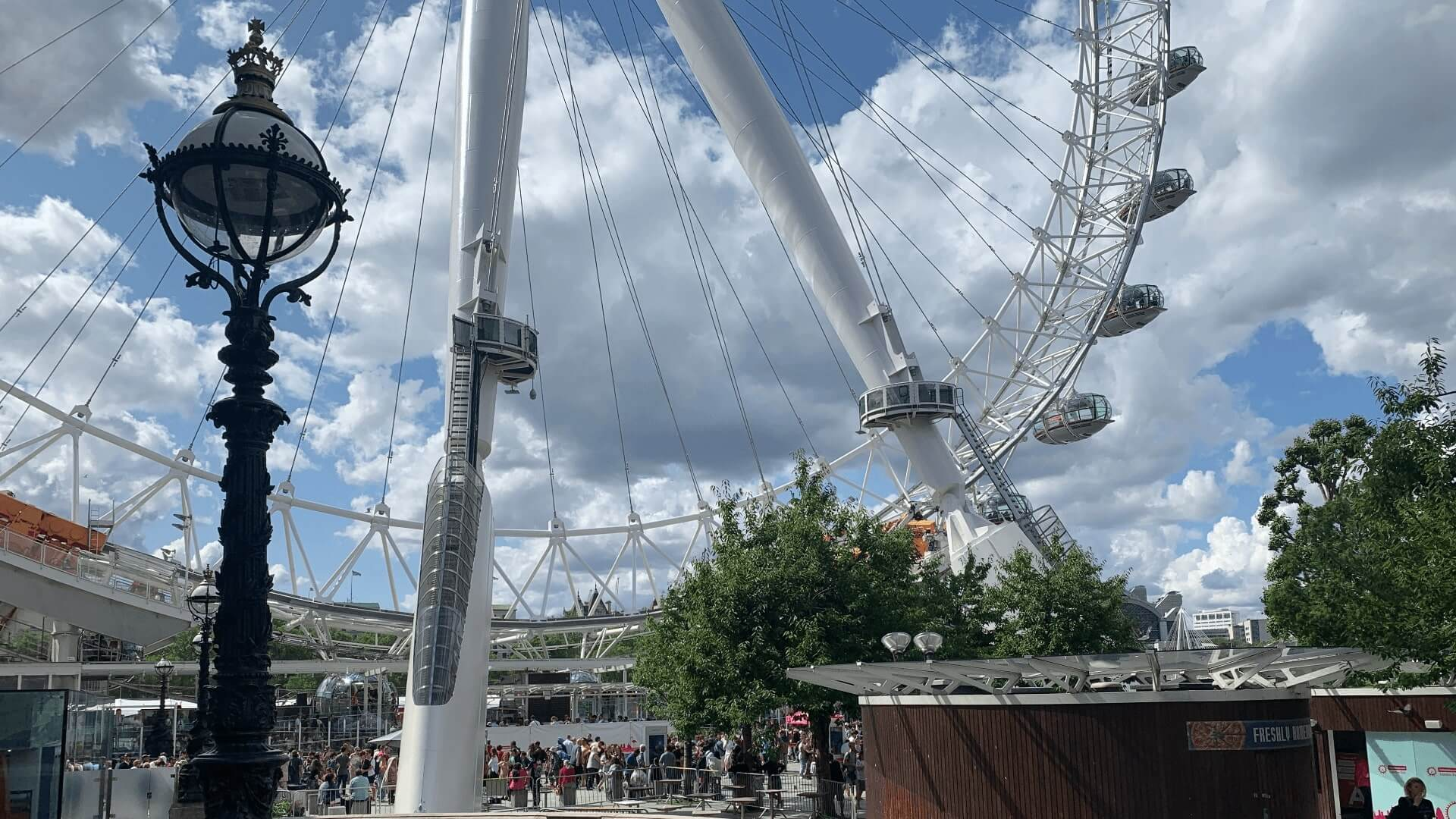 an old fashioned lamp post in front of the London Eye